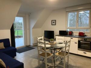 a kitchen and living room with a table and chairs at Gîte du Pré Rond in Saint-Gervais en-Belin