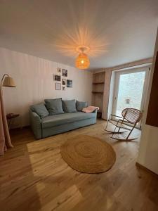 salon z niebieską kanapą i dywanem w obiekcie Chez SAM w mieście Langres