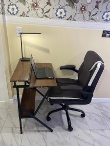 a desk with a chair and a laptop on it at A unique beautiful home in Elmont