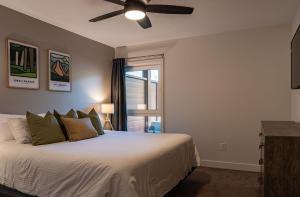 1 dormitorio con 1 cama y ventilador de techo en Granite Ridge Condo by Revelstoke Vacations en Revelstoke