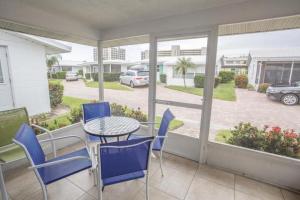 balcón con mesa y sillas y vistas a un aparcamiento en Villa 55 - Aloha Kai Vacation Villas, en Siesta Key