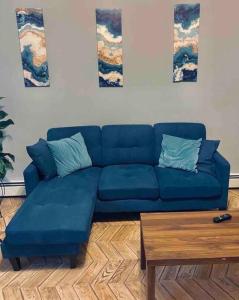 a blue couch in a living room with a table at Cozy up with me! Longer stays! Free parking in Troy
