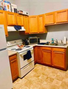 a kitchen with wooden cabinets and a white stove top oven at Cozy up with me! Longer stays! Free parking in Troy