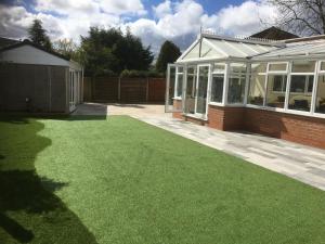 a garden with green grass next to a house at Welcome to your stay The Nest in Bolton