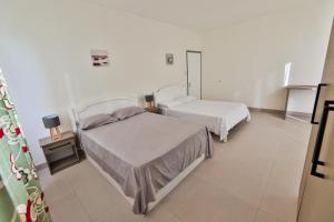 two beds in a room with white walls at OceanBreeze Apartments Mont Choisy in Mont Choisy