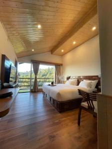a bedroom with a large bed and a large window at The Stone Age : a boutique hotel in Shimla