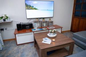a living room with a table and a projection screen at Vythee Residence in Chemin Grenier
