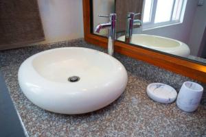 ein Badezimmer mit einem weißen Waschbecken und einem Spiegel in der Unterkunft Vythee Residence in Chemin Grenier