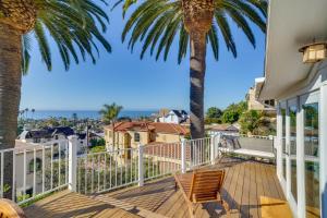 a deck with a palm tree and a chair at Stunning Ventura Cottage with Deck and Ocean View! in Ventura