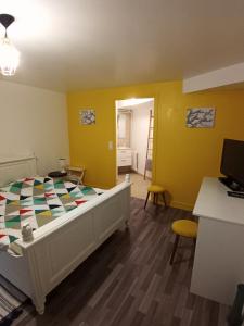 um quarto com uma cama num quarto com paredes amarelas em Logement indépendant avec parking privé et terrasse, au calme. em Coulaines