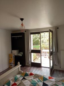 a bedroom with a bed and a sliding glass door at Logement indépendant avec parking privé et terrasse, au calme. in Coulaines