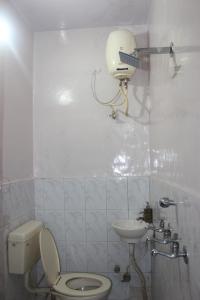 a white bathroom with a toilet and a sink at Namaste Amritsar Homestay in Amritsar