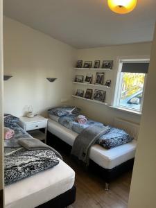 1 dormitorio con 2 camas y ventana en Jóhönnu Hús, en Hella