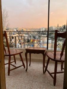 a balcony with two chairs and a view of a city at Homey Apt. with beautiful view in Amman