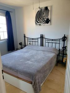 a bedroom with a bed with a zebra picture on the wall at 'Casa Ideal' A22 - Las Arenas Complex in Caleta De Fuste