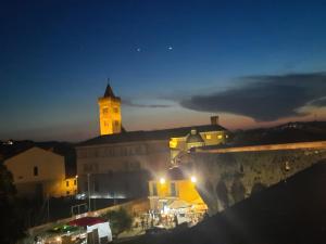 a building with a clock tower at night at Opera in Sarzana