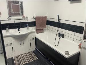 a bathroom with a tub and a sink and a shower at Butterfly House in Blackwood
