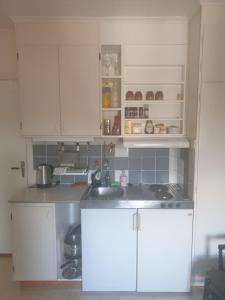 una cocina con armarios blancos y fregadero en Mycket Centralt Hel studio lägenhet, en Umeå