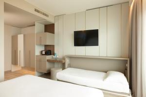 a bedroom with a bed and a tv on the wall at Adriatic Palace Hotel in Lido di Jesolo