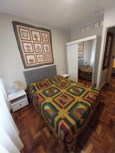 1 dormitorio con 1 cama con colcha colorida en Apto111consuladoamericano, en Porto Alegre