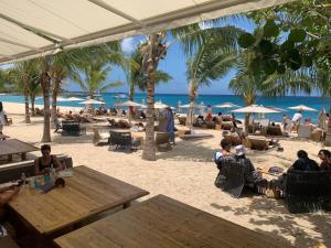 un gruppo di persone sedute ai tavoli sulla spiaggia di Cupecoy lagoon duplex a Lowlands