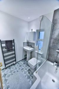 y baño con aseo, lavabo y ducha. en Church Retreat - A Magnificent Sea Side Apartment, en Hastings