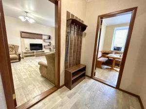 a living room with a mirror and a living room with a couch at ApartPoltava Велика однокімнатна квартира в Новому будинку, ЦЕНТР МІСТА, Банківський ЧЕК in Poltava +4 photos