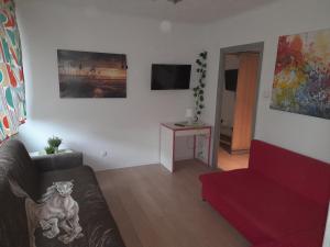 ein Wohnzimmer mit einem Sofa und einem roten Stuhl in der Unterkunft APARTAMENT LOTNIKÓW 7 in Płock