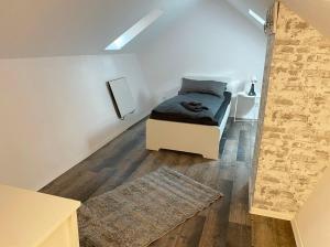 - une chambre avec un lit et un mur en briques dans l'établissement Cozy Apartments in Zwickau, à Zwickau