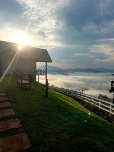 a bench sitting on top of a hill with the sun shining at Chalé Pico da Mantiqueira in Sapucaí-Mirim