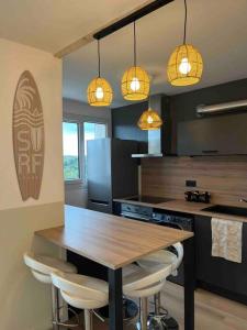 una cocina con una mesa de madera y algunas luces en Appartement cosy - 3 chambres - 700m centre Ecully, en Écully