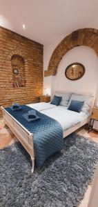 een groot bed in een slaapkamer met een bakstenen muur bij Altstadt Speyer in Speyer
