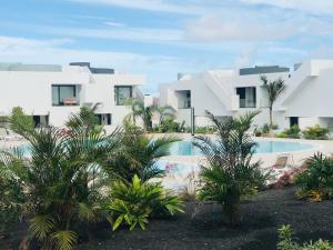 een uitzicht op een resort met een zwembad en palmbomen bij CASA Pura Vida, Fuerteventura in La Oliva