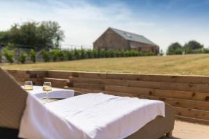 a table with two glasses of wine and a barn at La Roche-Barn with hot tub on the Welbeck estate in Holbeck