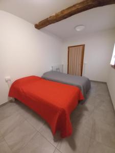 een slaapkamer met een bed met een rode deken bij casa vacanze cedro in San Lazzaro di Savena