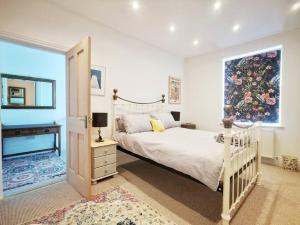a bedroom with a bed and a large window at Gensing Lodge - A Beautiful Artistic Maisonette in St. Leonards
