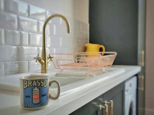 a mug sitting on a kitchen counter next to a sink at Gensing Lodge - A Beautiful Artistic Maisonette in St. Leonards
