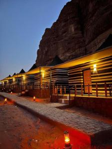 budynek z oświetleniem przed górą w obiekcie SOlARIS WADI RUM CAMP w mieście Wadi Rum