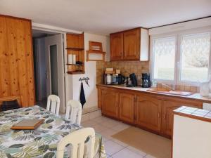 a kitchen with a table and chairs and a kitchen with a refrigerator at Appartement cosy à Bussang in Bussang