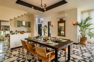 a dining room and kitchen with a table and chairs at La Viola Estate in Anjuna