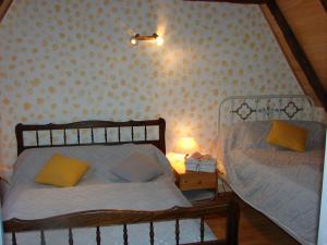 a bedroom with two beds and a lamp on a night stand at La vallée de l'Ouysse in Lacave