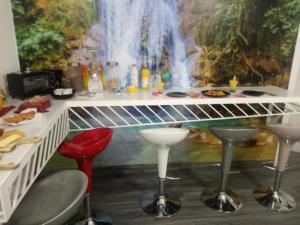 a bar with stools and a painting of a waterfall at Il Paradiso di Marilyn in Milazzo