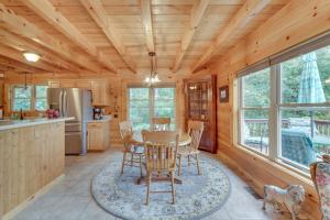 Cozy North Carolina Cabin - Deck, Grill and Fire Pit في Bostic: مطبخ وغرفة طعام مع طاولة وكراسي