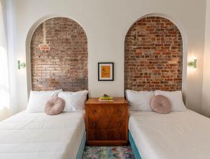 two beds in a room with two archways at The Bellwether Hotel in Louisville