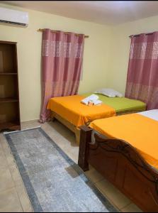two beds in a room with purple and orange at DOÑA CORNELIA in Los Patos