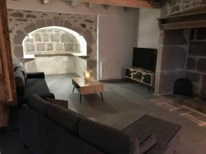 a living room with a couch and a fireplace at GITE pour famille in Saint-Clément