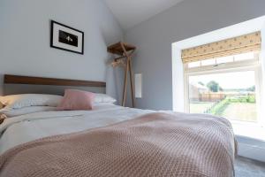a bedroom with a large bed with a window at La Roche-Barn with hot tub on the Welbeck estate in Holbeck
