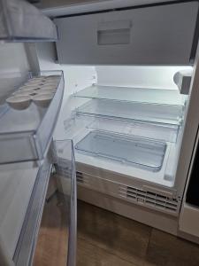 an empty refrigerator with its door open in a kitchen at Wellenrauschen - Whirlpool Badewanne - Terrasse - Ruhig gelegen in Wilhelmshaven +20 photos
