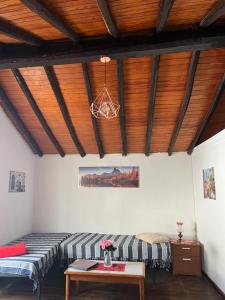 a room with two beds and a table and a ceiling at Casa en Teror Céntrica turismo de ciudad y bosques in Teror