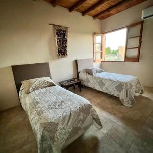 a bedroom with two beds and a window at Complejo ROSA OLIVA in Albardón